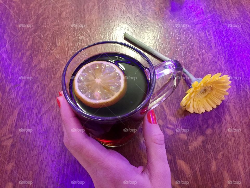 Woman s hand holding a cup of ginger tea with lemon