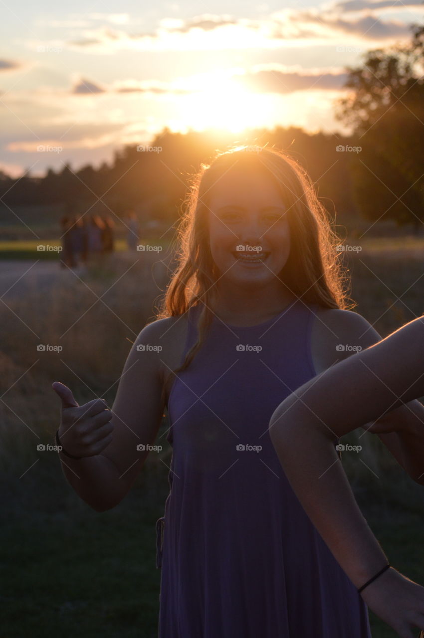 teenage girl smiling in the orange sunset