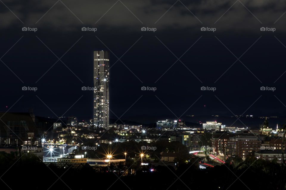 City houses and buildings with lots of lights coming from the windows and lamps in the evening 