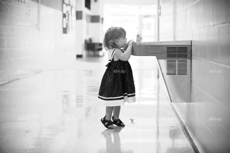 Cute girl standing in corridor near wash basin