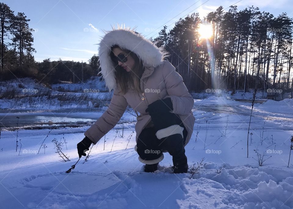Young woman making heartshape on snowy land