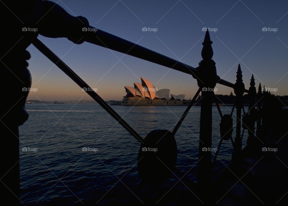Black foreground adds interest and leads the eye in to a much photographed tourist icon at dusk in Sydney, Australia.