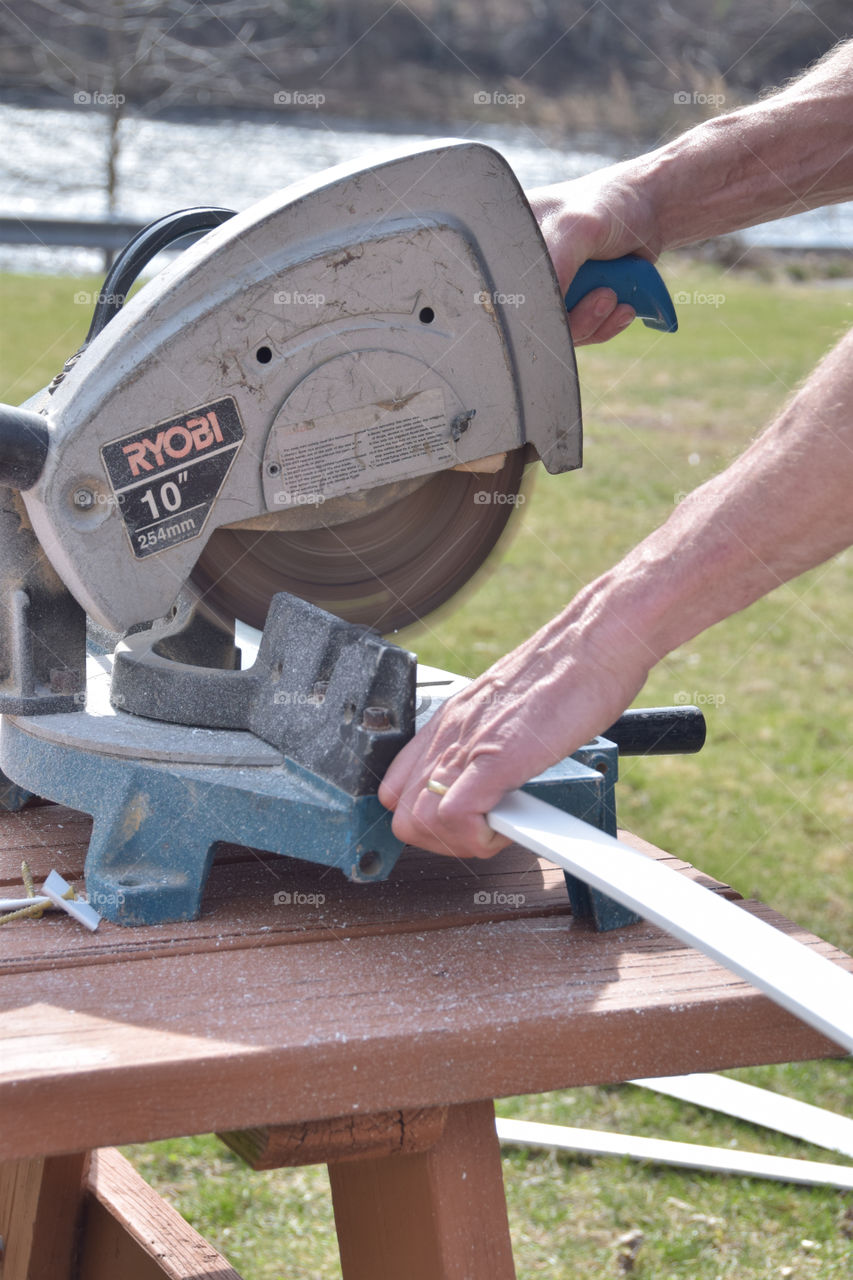 DIY home improvement, cutting wood using a circular saw by the riverside in the backyard