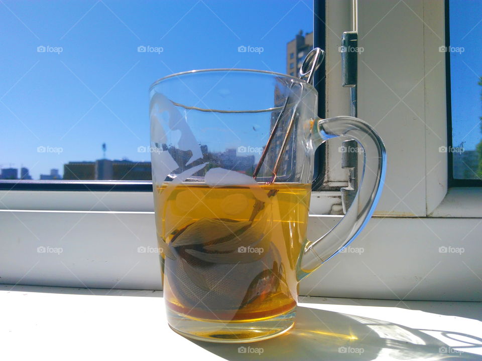 a cup of green tea is on the windowsill