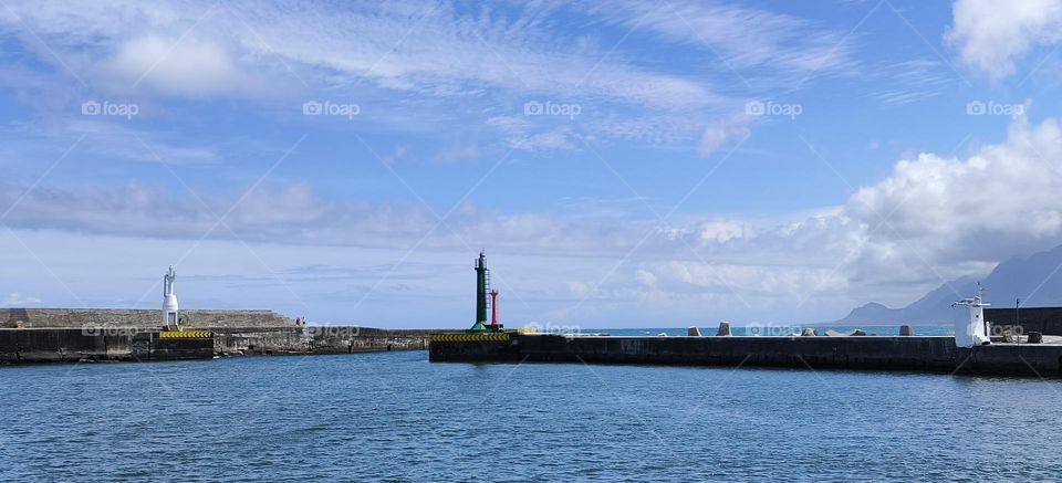 Lighthouse and blue sky with white clouds