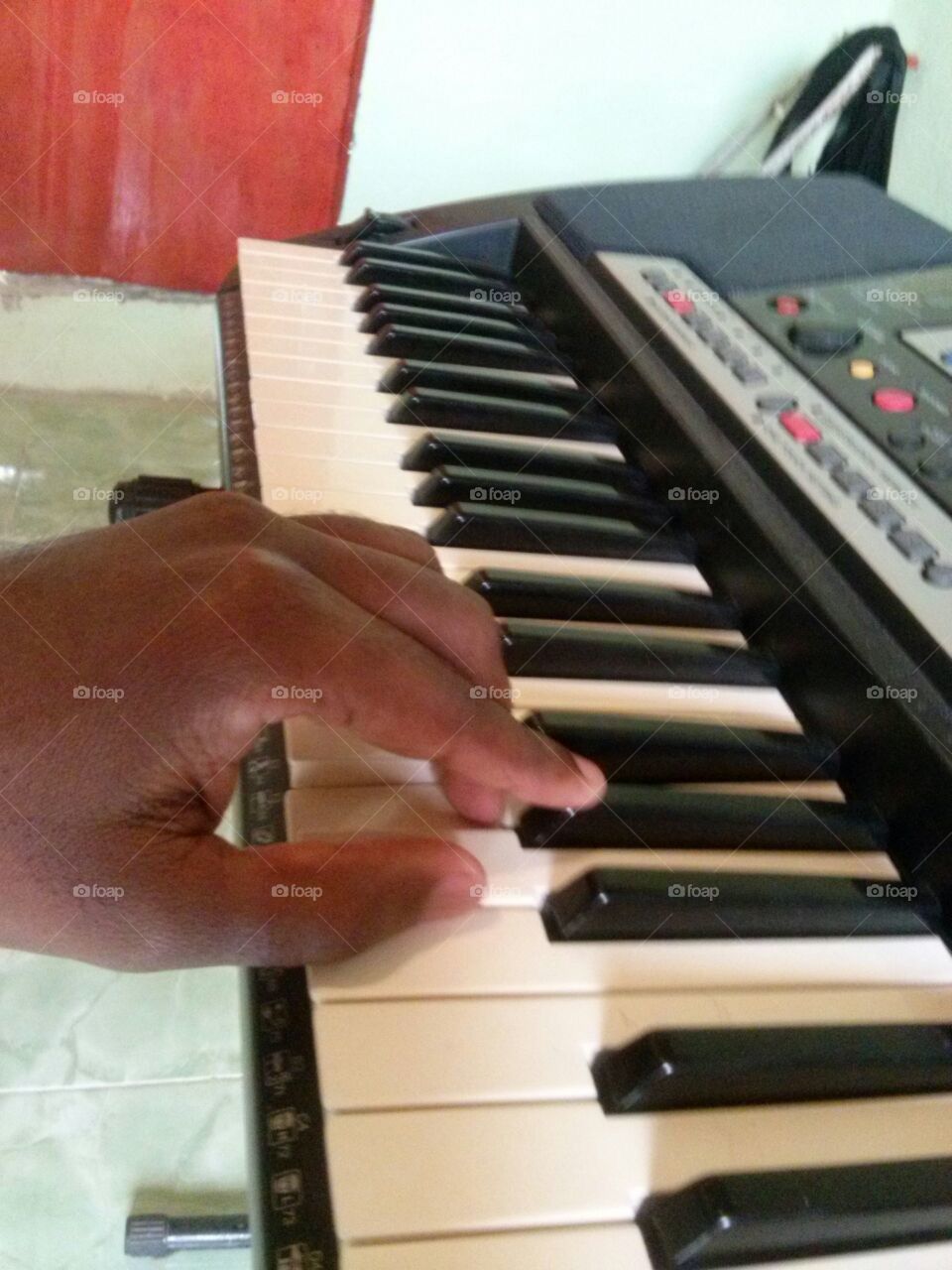 Tocando teclado com a mão esquerda.