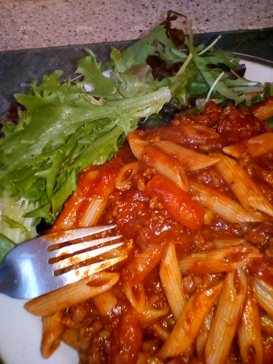 Spaghetti Bolognese with side salad leaves