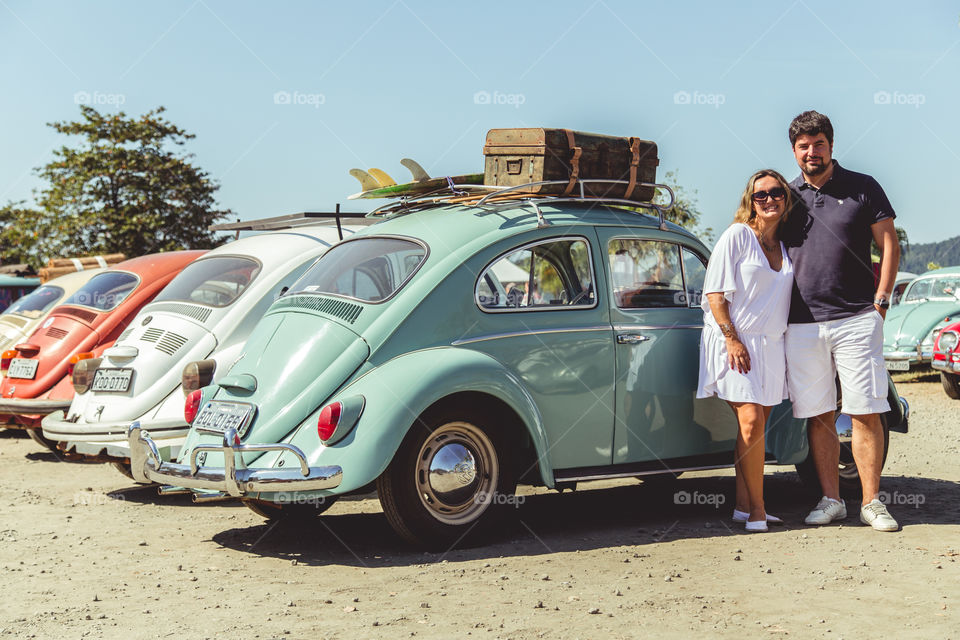 Lovely couple on vacations with a Volkswagen Beetle 