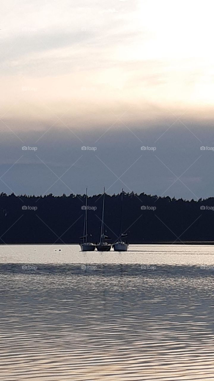 three sailing boats will sleep on the lake, silent evening