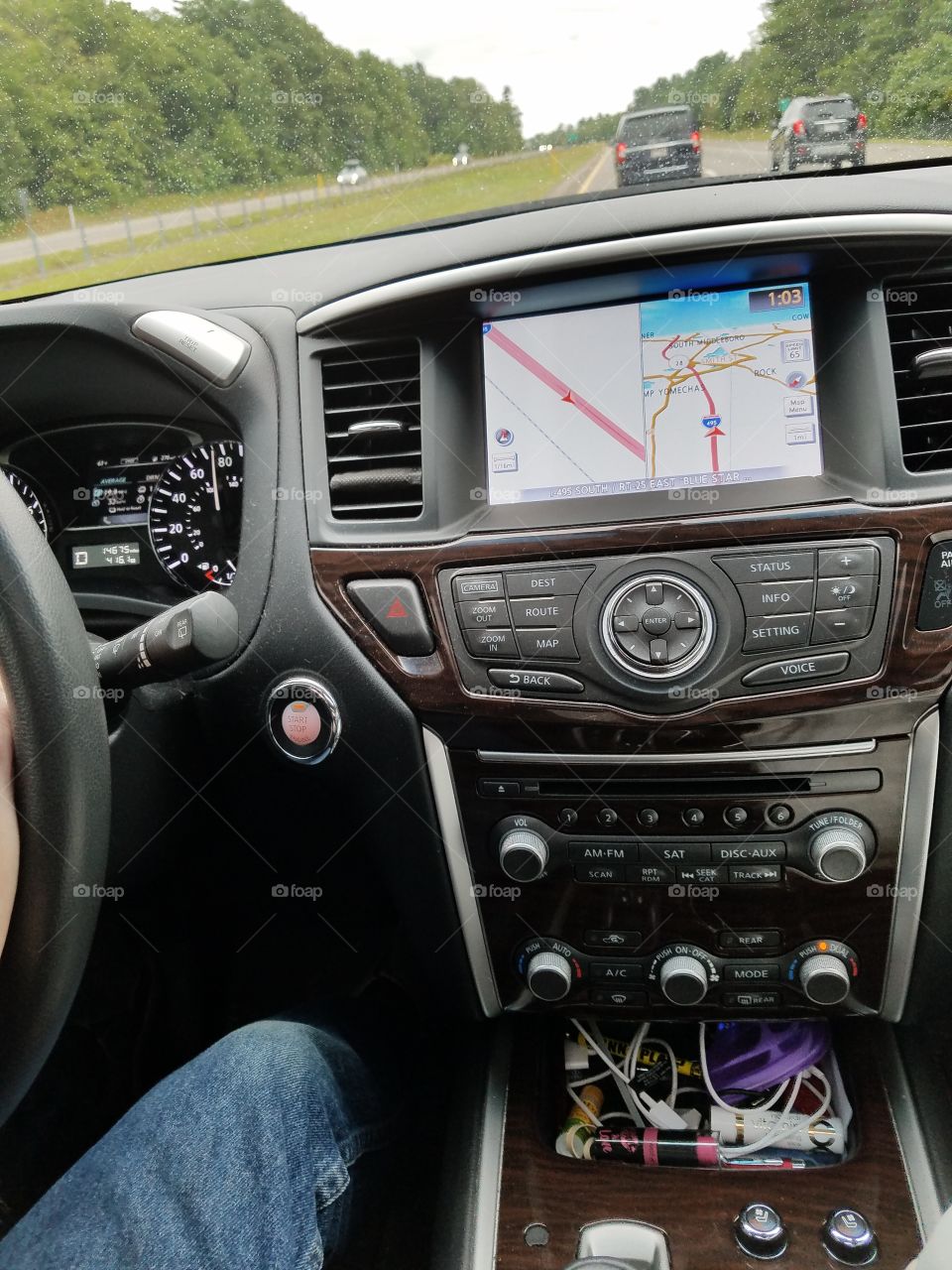 Driving keyless SUV cockpit, dials, steering wheel, GPS, radio controls, color black, highway drive, windshield.