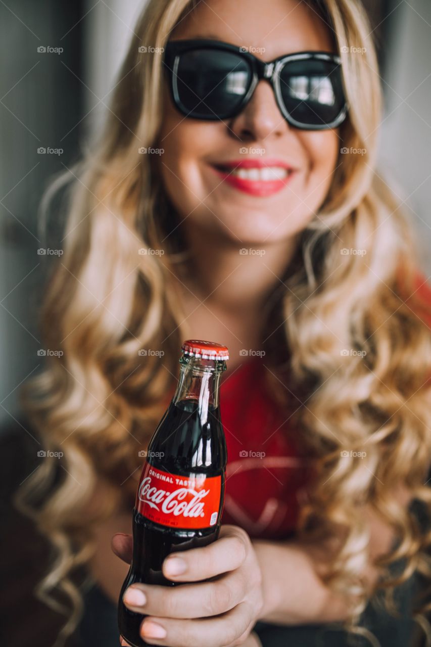 Girl holding a Coca Cola bottle 