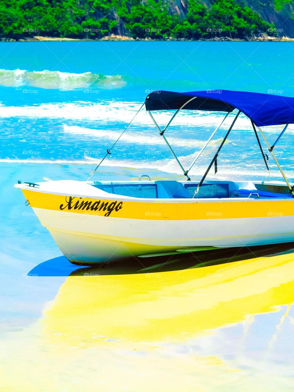 Beautiful Blue and yellow boat on a paradisiacal Beach, with blue ocean waters and white sand, in Brazil