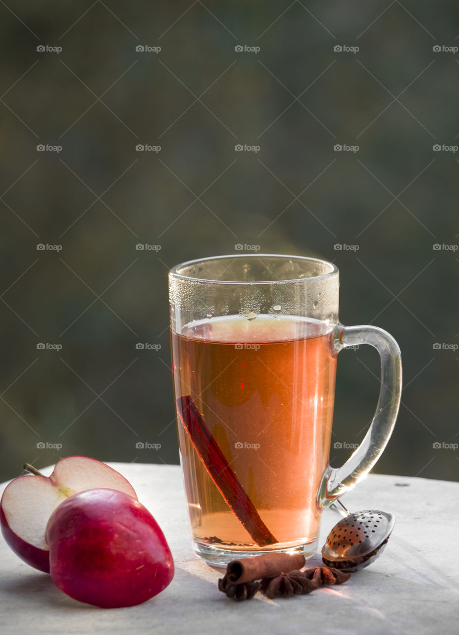 a cup of tea with.cinnamon and apples