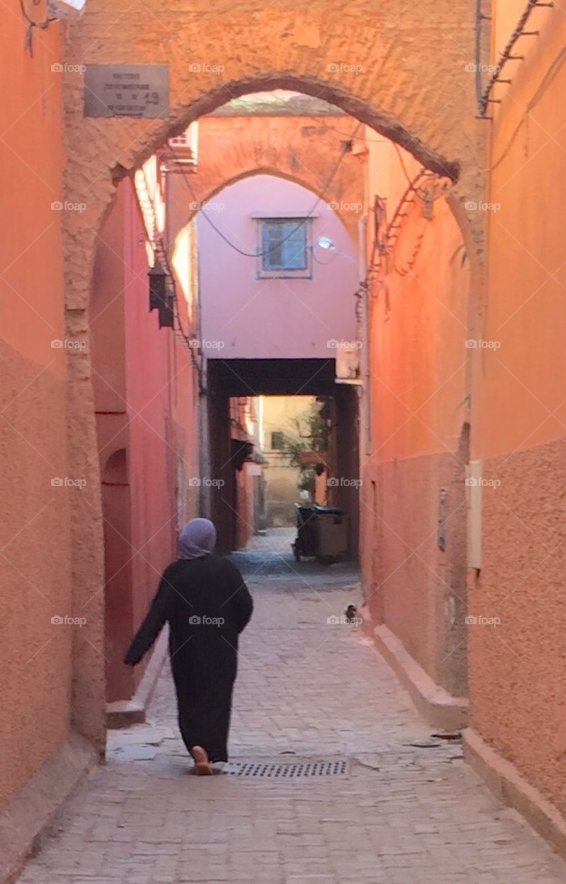 A woman walks along an alley in the Médina