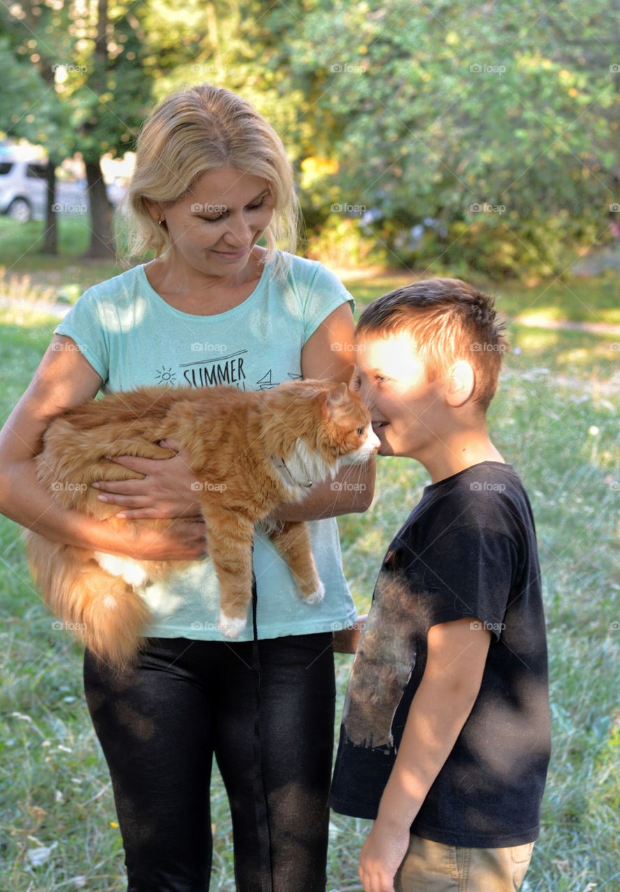 cat on a hands woman and child family outdoor