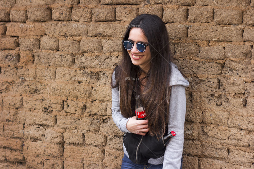 Young woman holds Coca-Cola bottle