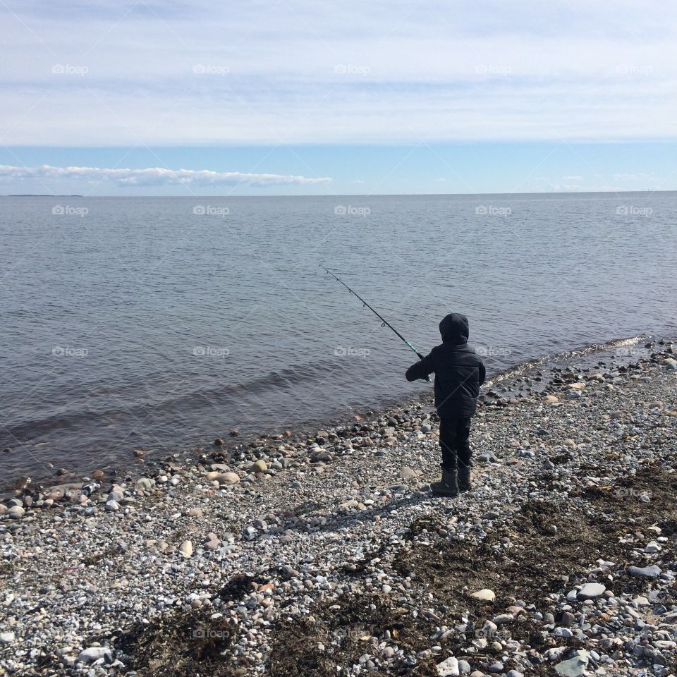 Fishing. Boy fishing in ocean