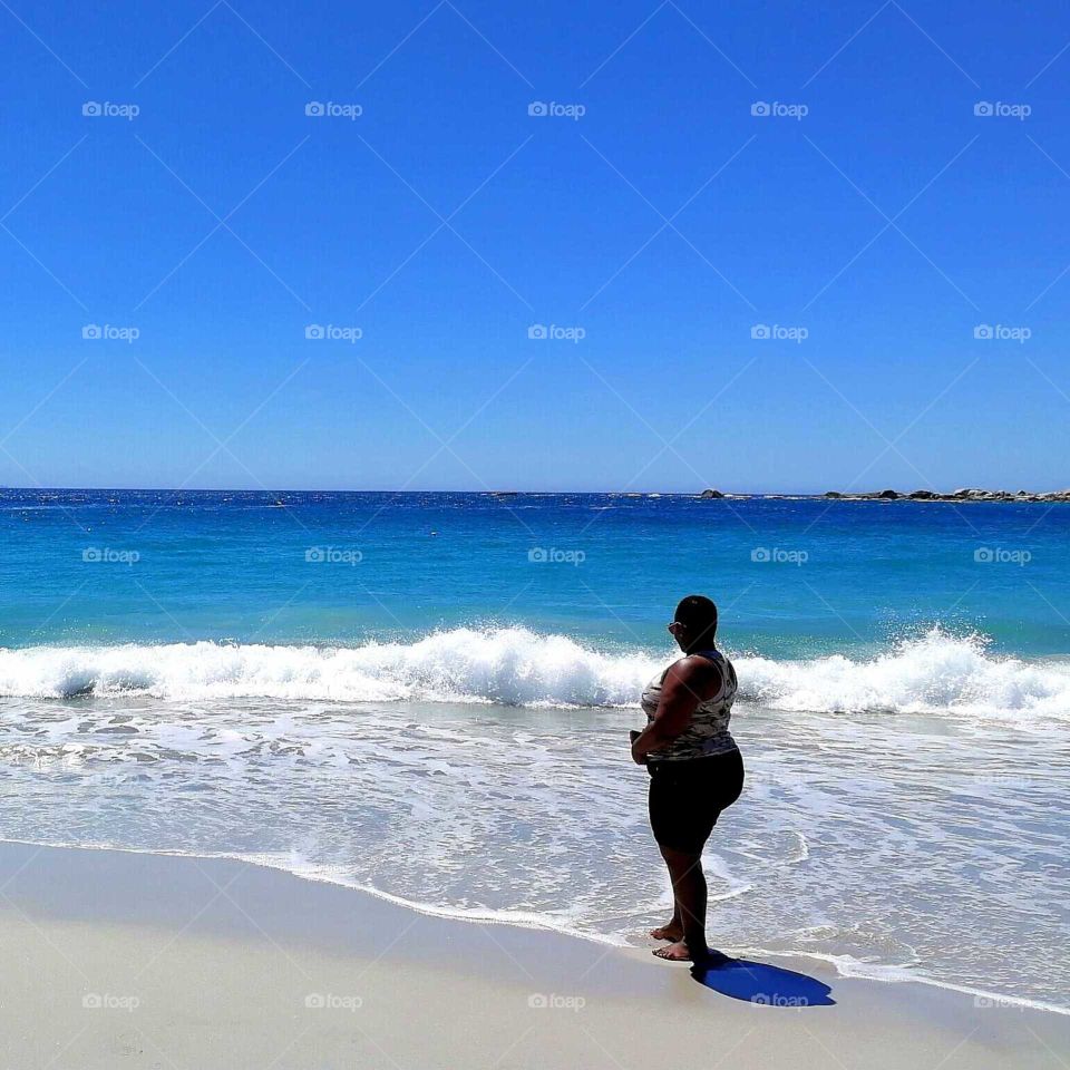 black woman watching the blue sea