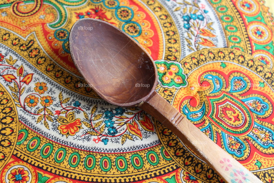 Wood traditional spoon on coloured towel