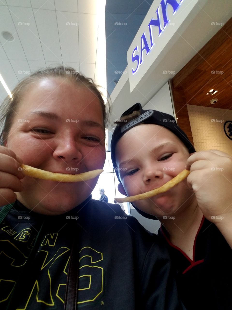 Mother and son smiling with french fries.
