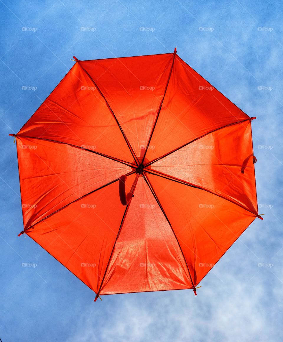Orange umbrellela on blue sky background
