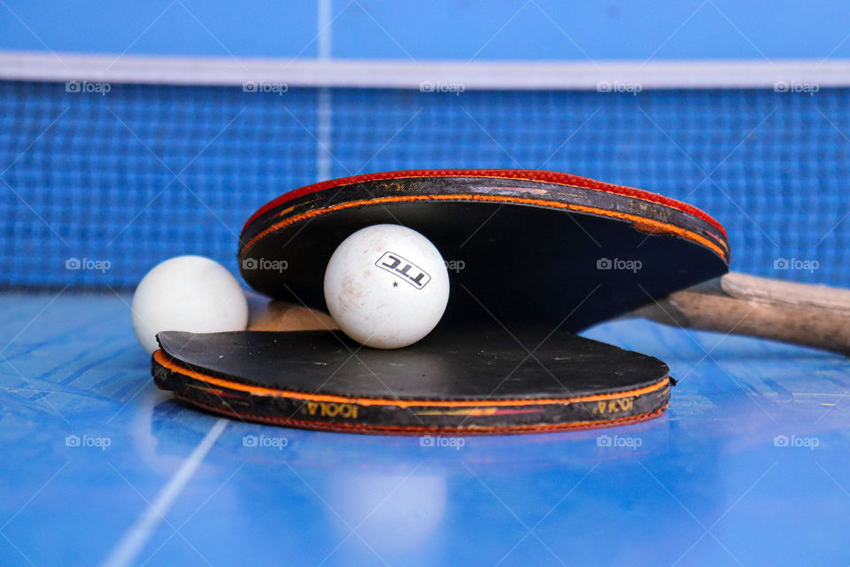 Table tennis rackets in front of a table tennis net