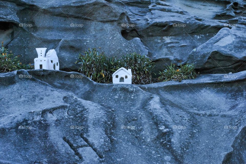 A white model house on the rocks.