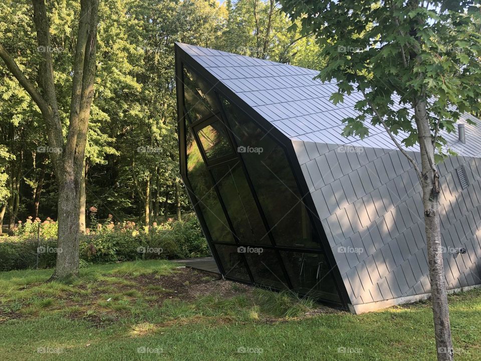 Tiny modern house in metal and glass at the green nature 