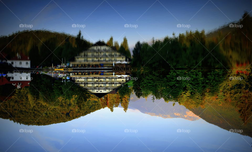Reflection of building and autumn trees on lake