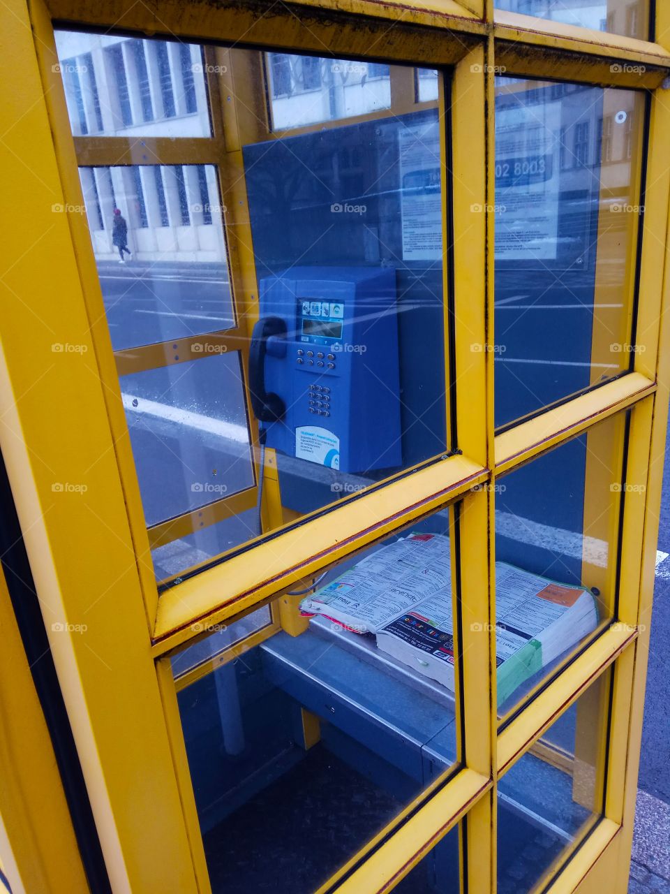 Yellow phone box with a printed catalogue