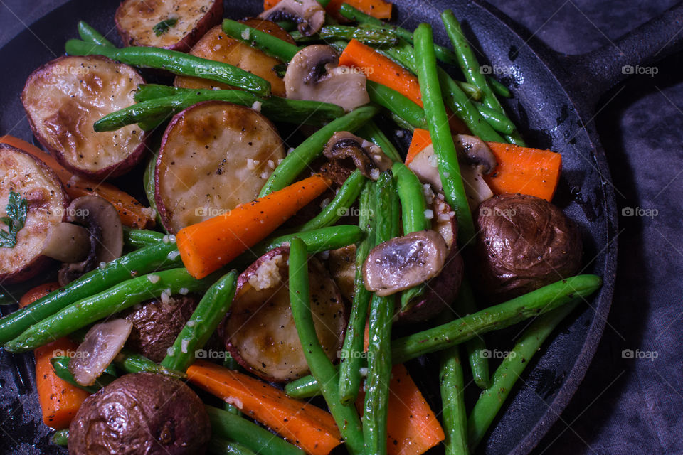 roasted carrots, green beans, mushrooms, and red potatoes on black roasting pan