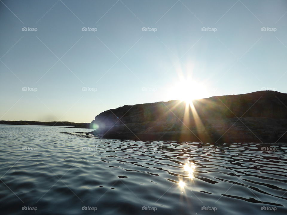 sunrays over a cliff in the sea