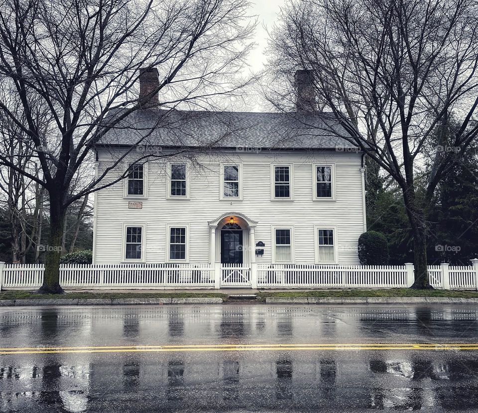 House reflection on a rainy road