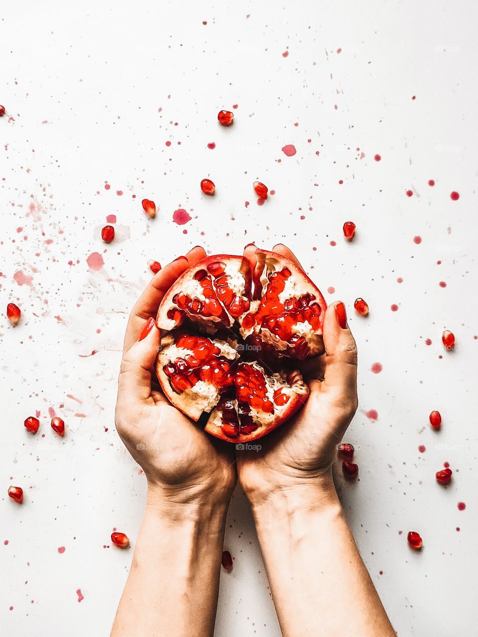 The fruit of the pomegranate in the woman hands