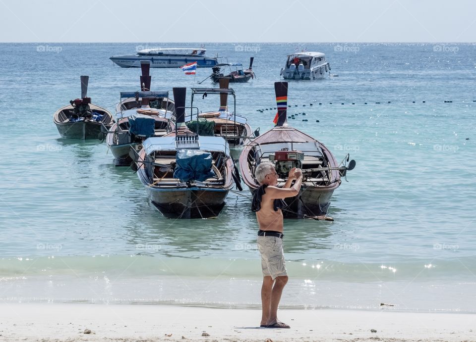 Camera man and Beautiful boat in the blue sea