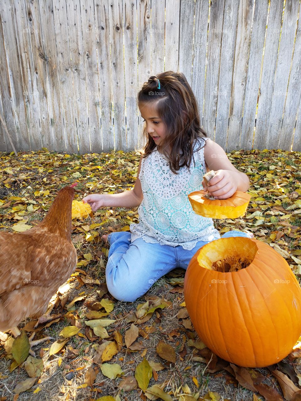 child carving pumpkin outdoors