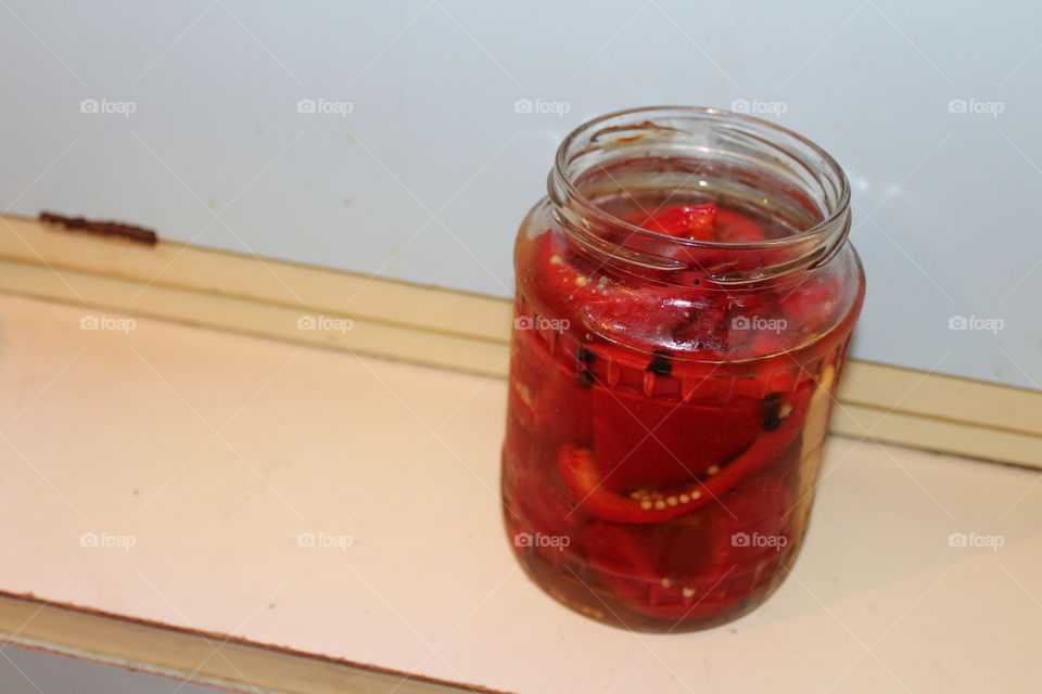 red peppers in vinegar in a transparent jar