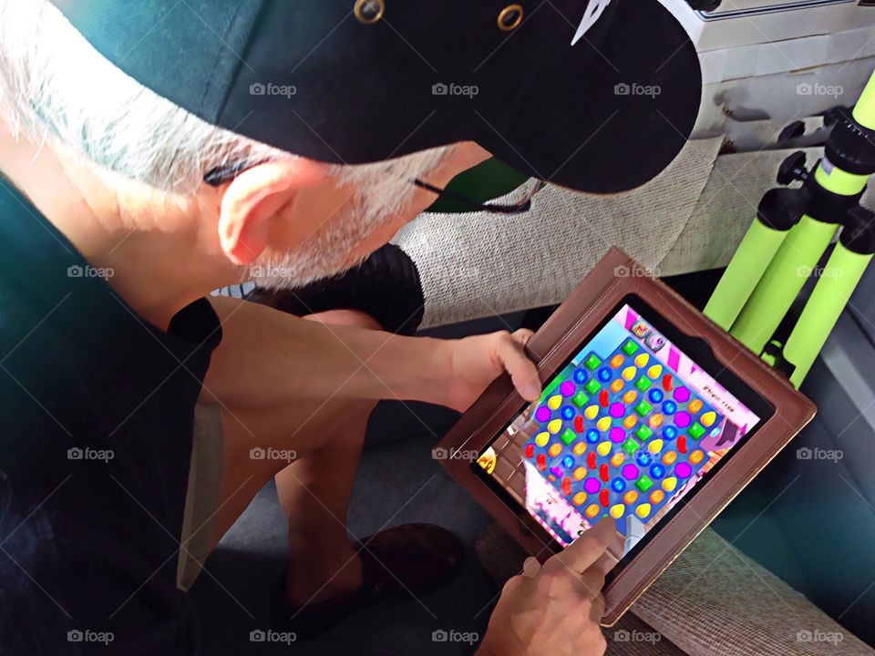 Man taking a break and playing a colorful game on his favorite computer tablet.