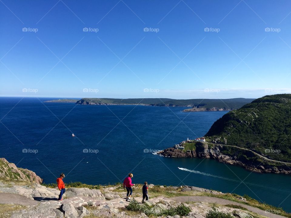 Family enjoying vacation sights on the trails of Signal Hill with the Narrows of St. John's, NL harbour, Fort Amherst and Cape Spear in the distance. 