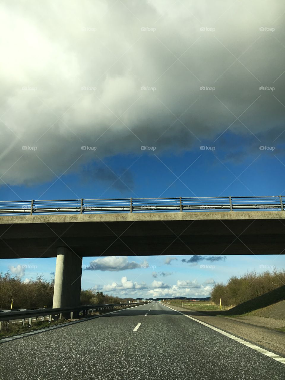 Driving under the bridge. Grey clouds hanging low.
