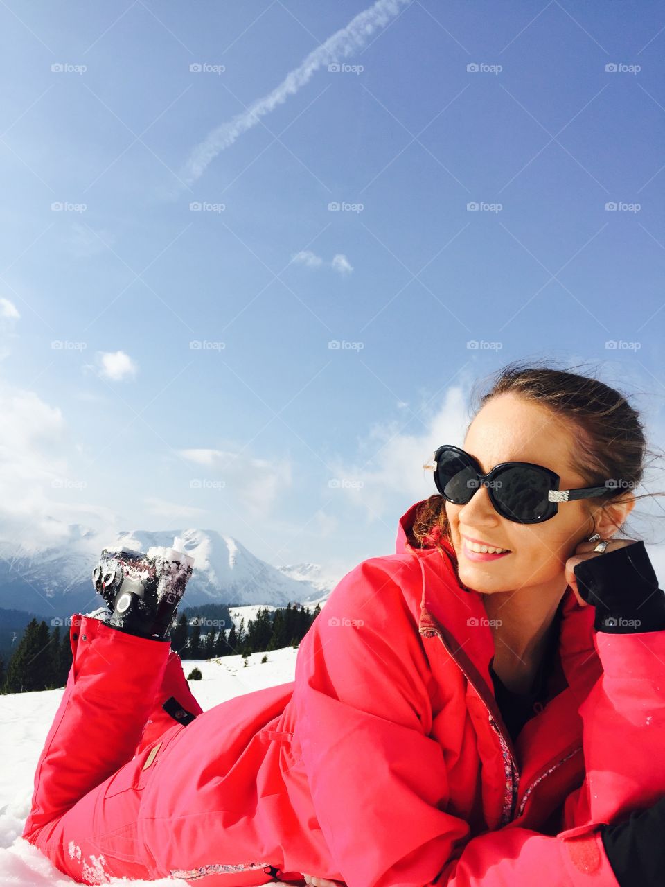 Stylish woman lying on snowy land