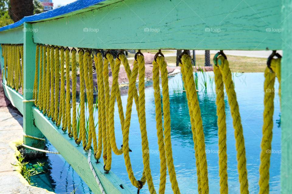 Wooden fence with roping along a pond