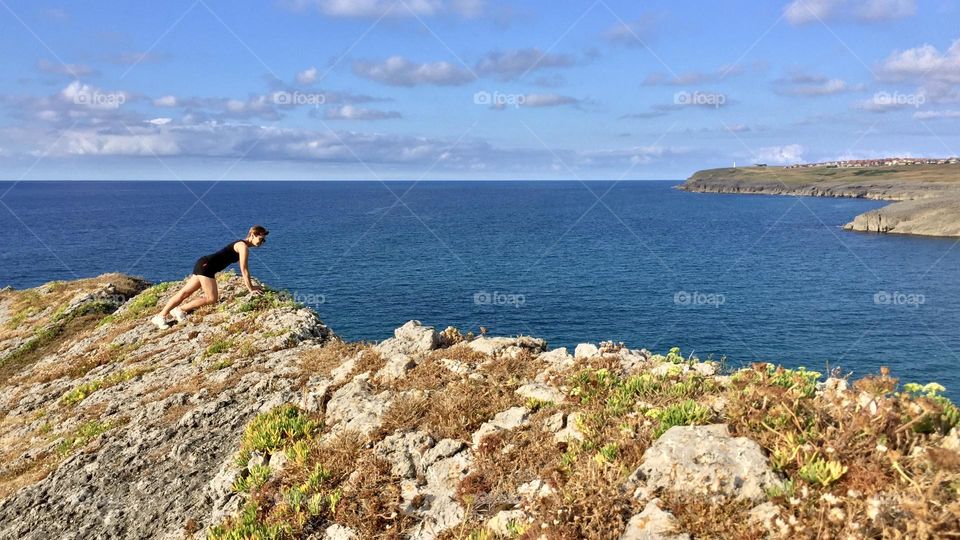A hiker looks out onto the cliff