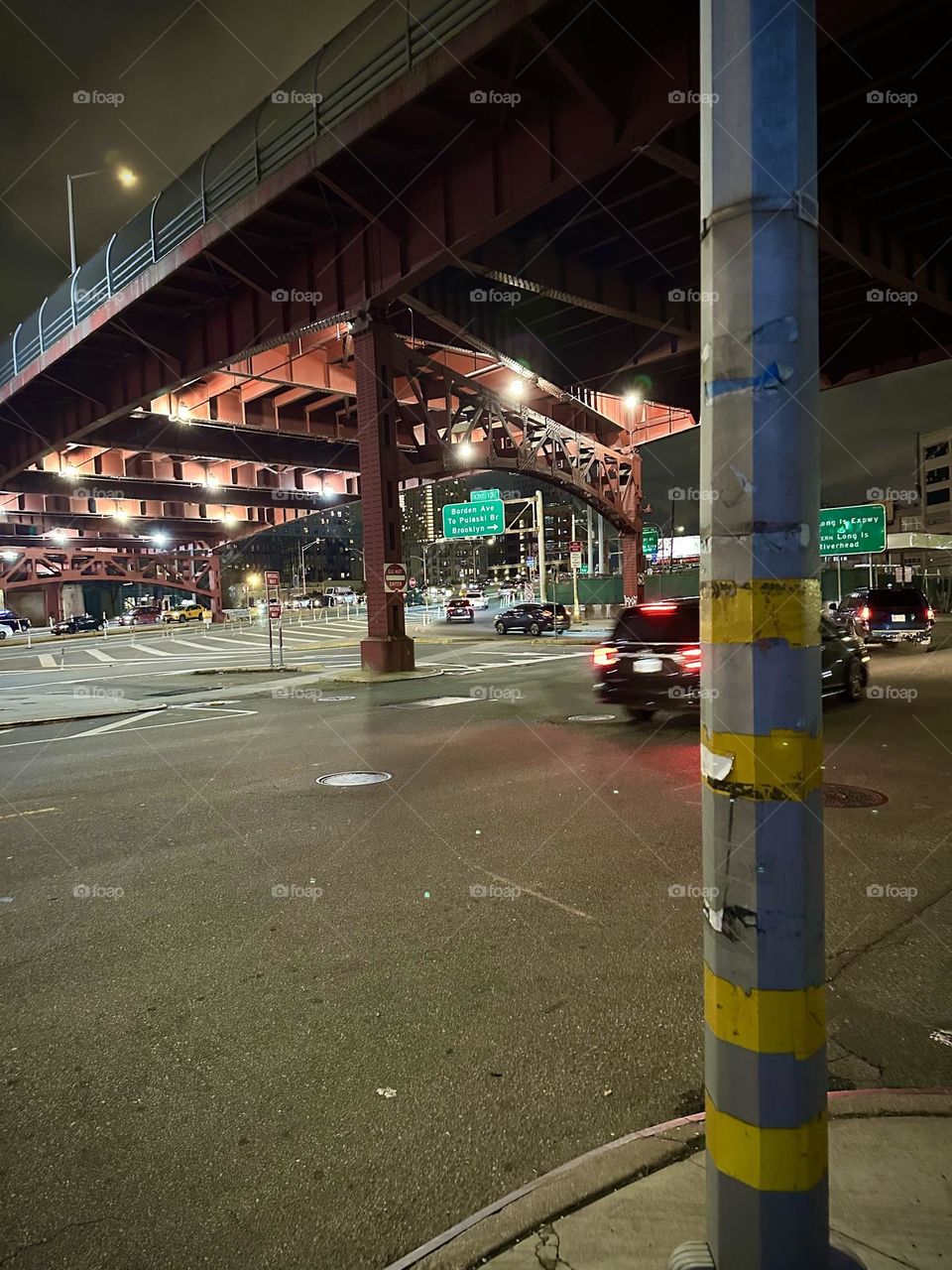 This is “Borden Avenue” beneath the “Pulaski Bridge” in LIC, Queens with multiple spotlights on its underside to illuminate the way for all the cars driving through. 2023. Hypnotic Productions