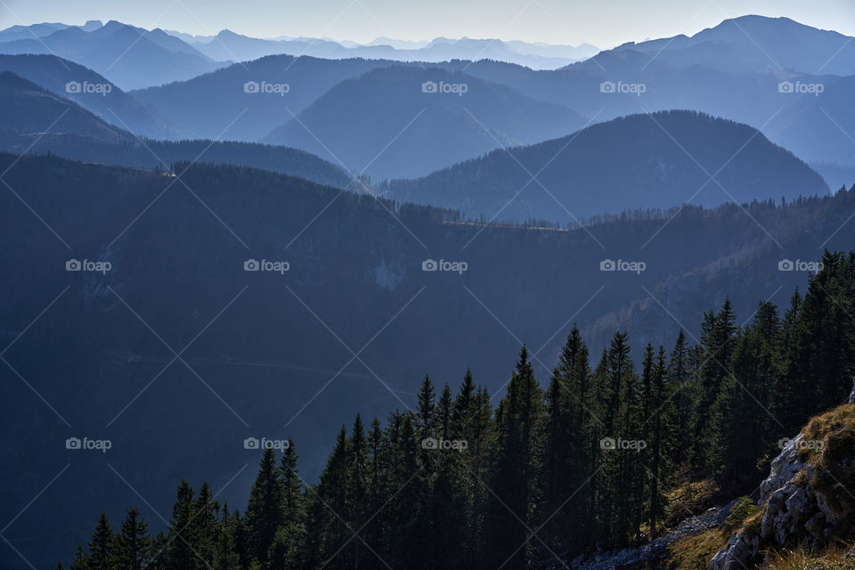 Mountain range with visible dark blue silhouettes through the fog 