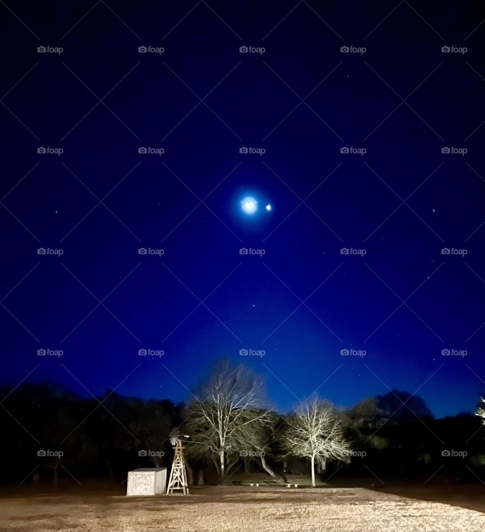 Color explosion of a vibrant deep blue sky with the moon, Venus and the stars on a clear night. 