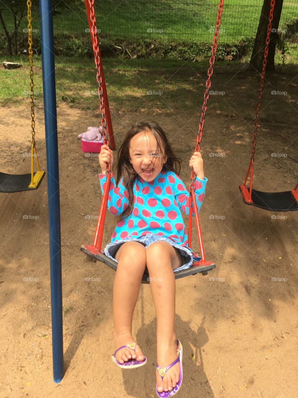 Girl on swing laughing 