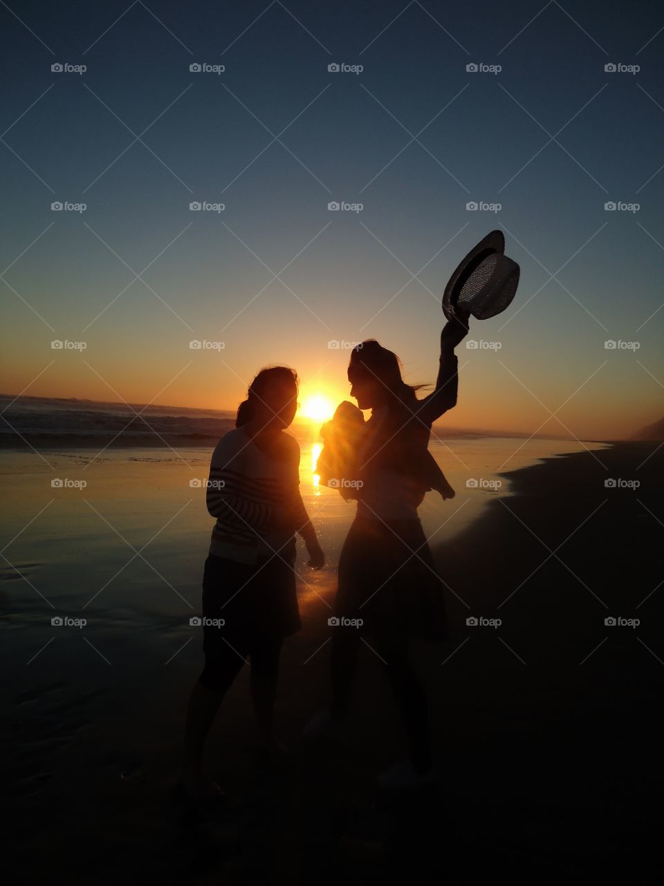 Silhouette at the beach of two young girls