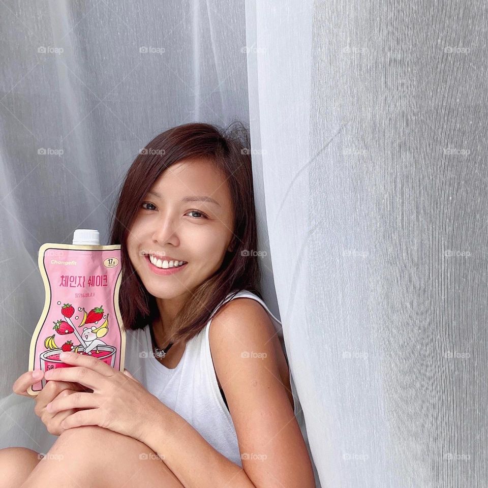 Asian woman holding Protein shake from korea in tasty flavours 