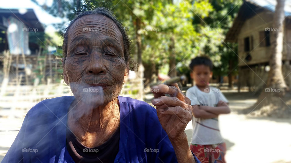 face with nice tatoo in Myanmar while smoking